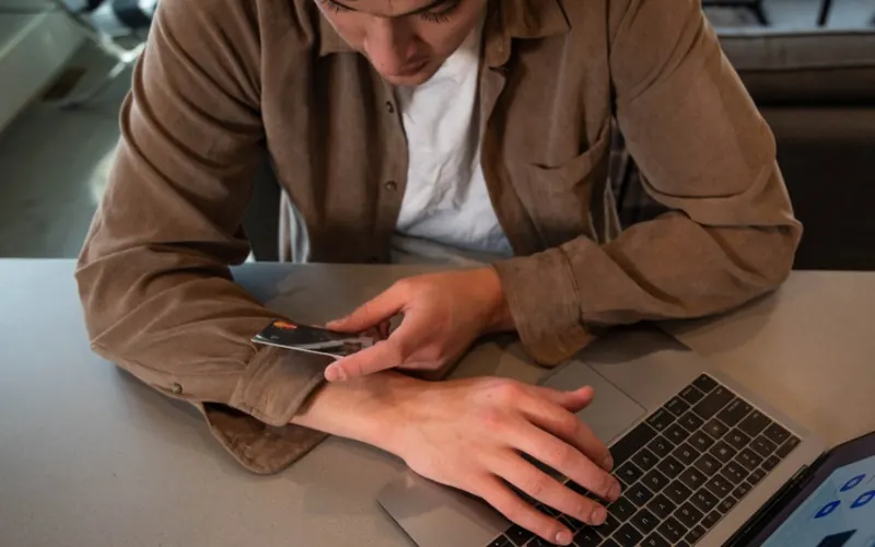 Homem com notebook e cartão no escritório