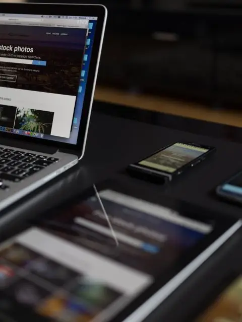 Notebook e tablets sobre uma mesa escura