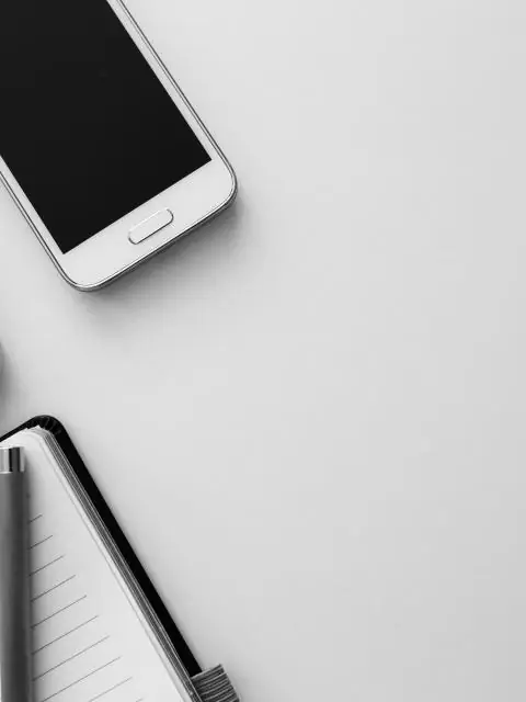 Smartphone sobre um caderno em mesa clara